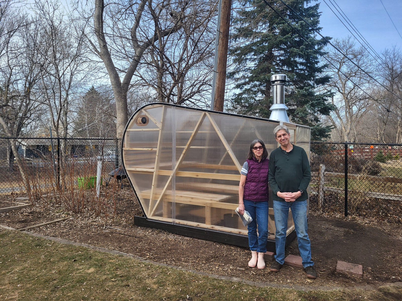 Owners of a NorthUp sauna standing in front of their newly delivered sauna.