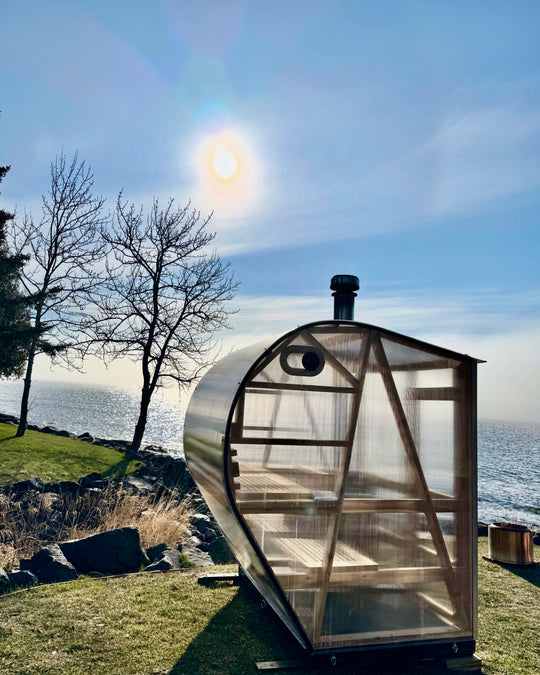 NorthUp Curve outdoor sauna install next to lake with sunshine in the backryard.