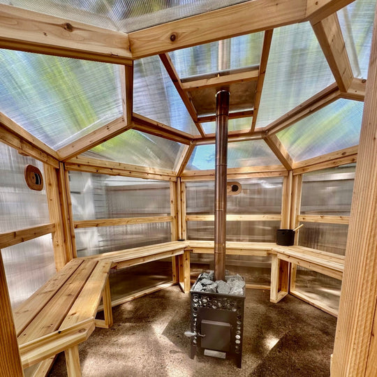 Interior of translucent panels of NorthUp Hex sauna and benches with stove in the middle.