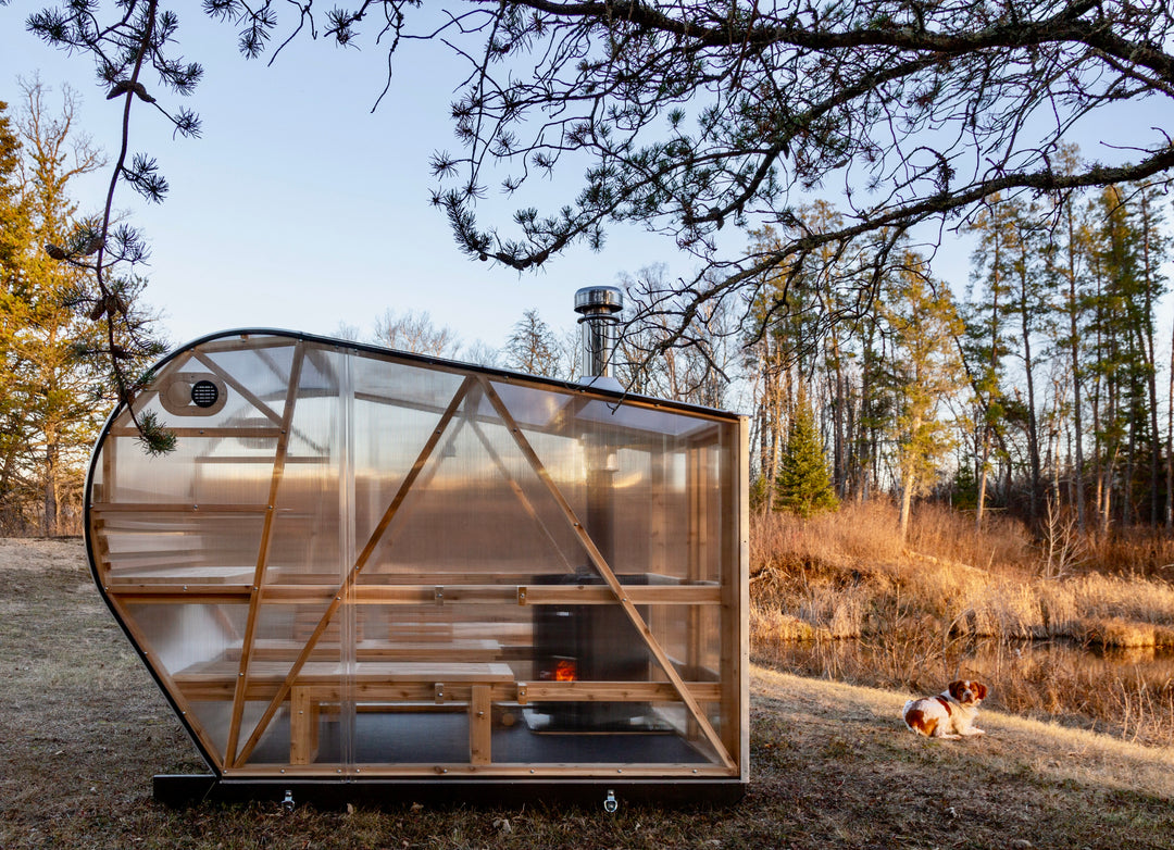 NorthUp Curve XL exterior view of the side profile of the sauna. Installed lakeside with trees in background.