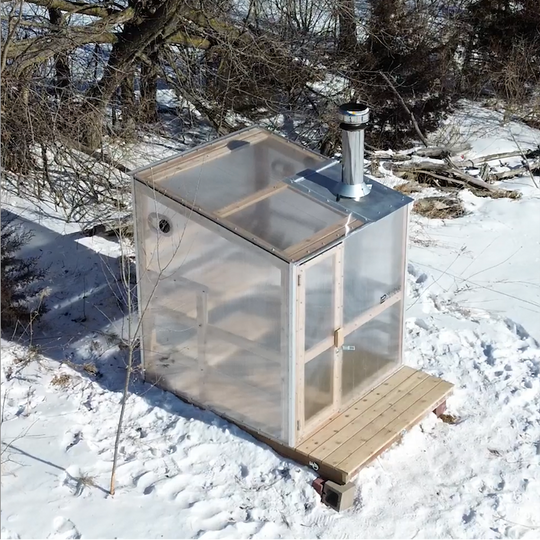NorthUp Core polycarbonate transparent sauna viewed from overhead in a snowy field