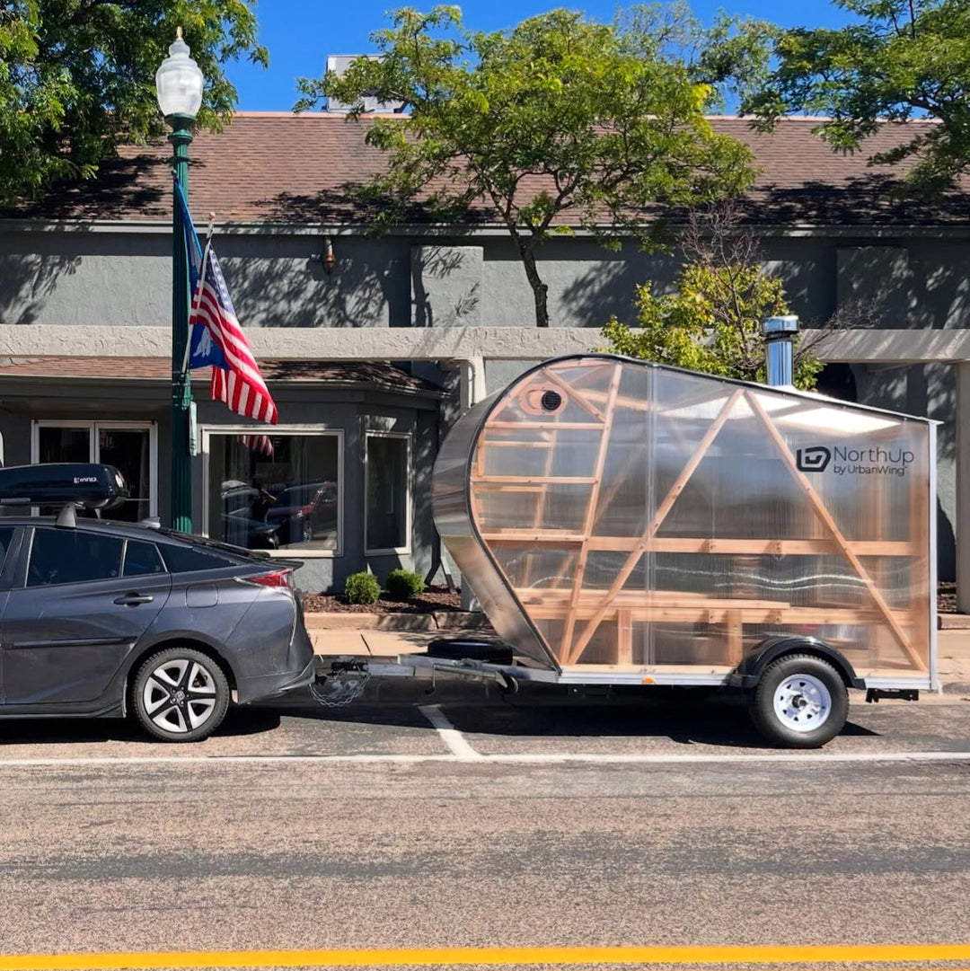 NorthUp Sauna XL mobile sauna trailer being towed by a Prius vehicle.