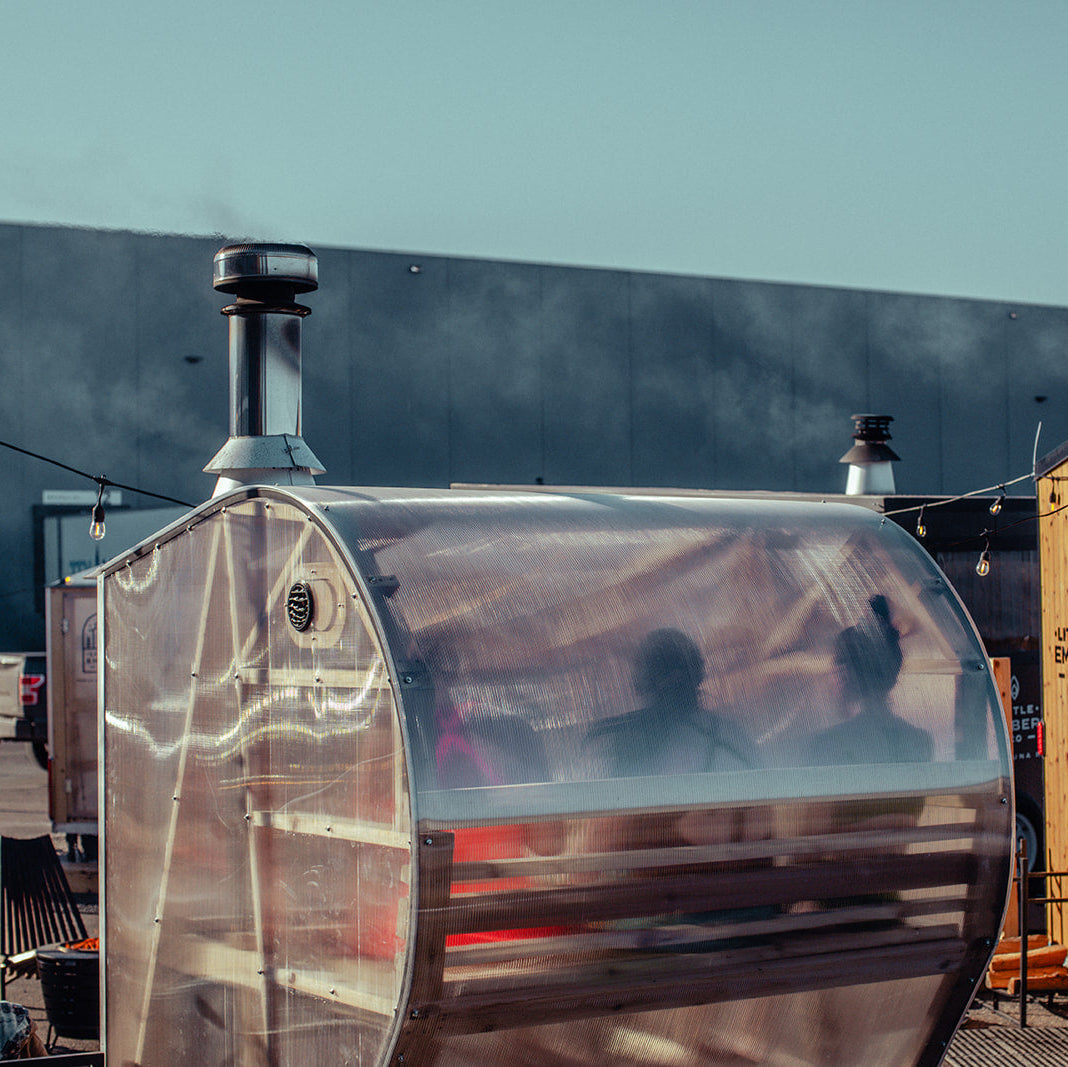 Exterior rear view of two people inside of a NorthUp Curve sauna